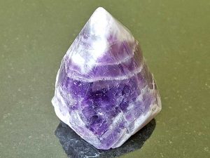 Highly polished Amethyst Chevron Point approximate height 55 mm. Being a natural product this crystal may have natural blemishes and vary in colour. www.naturalhealingshop.co.uk based in Nuneaton for crystals, spiritual healing, meditation, relaxation, spiritual development,workshops.