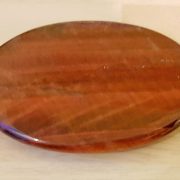 Highly polished Red Tiger Eye palm stone 70 x 40 mm. The palm stones are made from the best grade rough materials to produce a well finished, highly polished product. Used by crystal healers and general therapists for massage and similar treatments. Also perfect for collectors. Being a natural product these stones may have natural blemishes and vary in colour and banding. www.naturalhealingshop.co.uk based in Nuneaton for crystals, spiritual healing, meditation, relaxation, spiritual development,workshops.